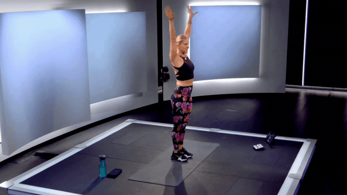 Peloton instructor Rebecca Kennedy demonstrates a standing bicycle crunch during a standing core class on the Peloton App