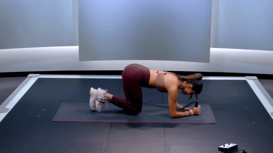Peloton instructor Hannah Corbin demonstrates a kneeling glute kickback.