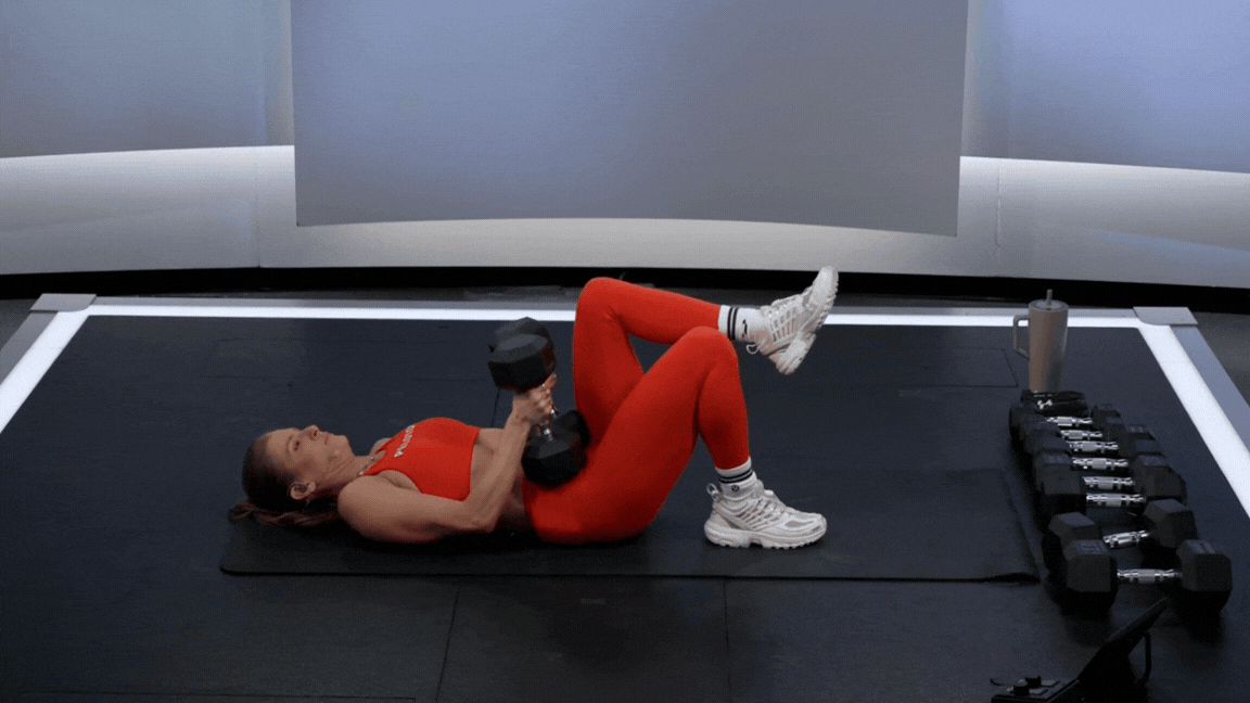 Peloton instructor Rebecca Kennedy demonstrates a single-leg glute bridge dumbbell leg exercise.