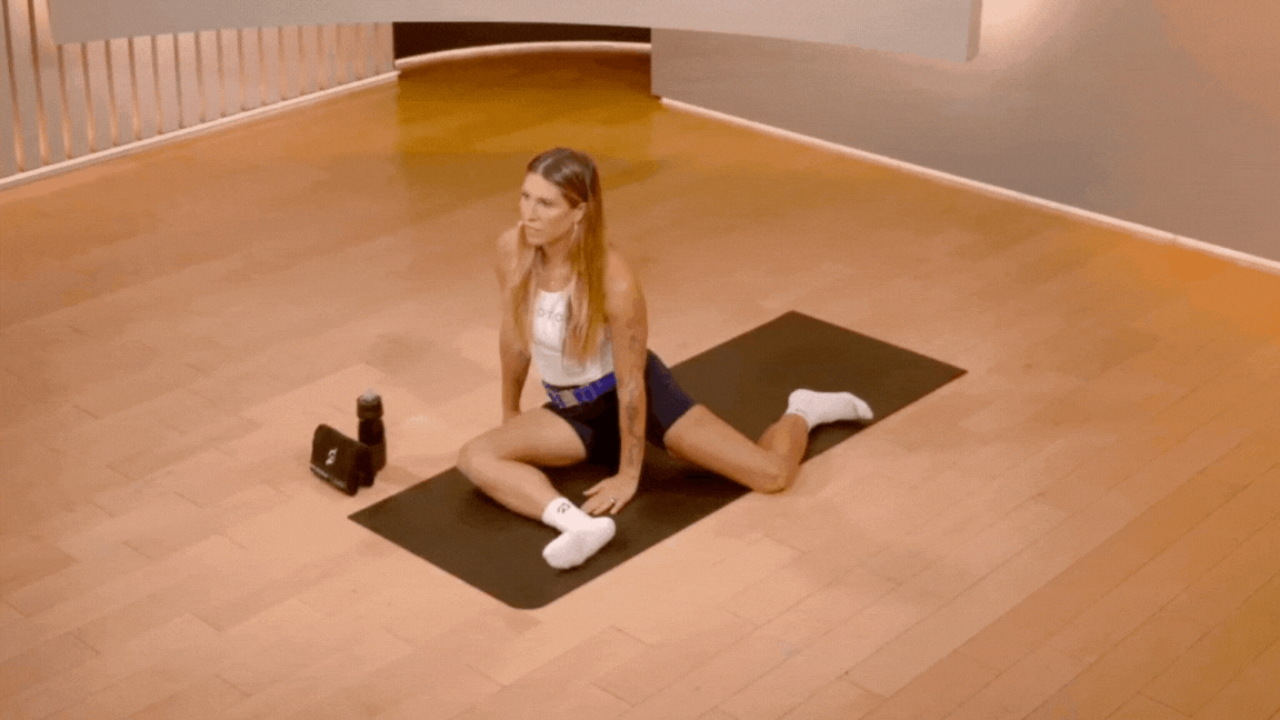 Peloton instructor Selena Samuela demonstrates a 90-90 hip internal rotation lift during a Peloton mobility class.