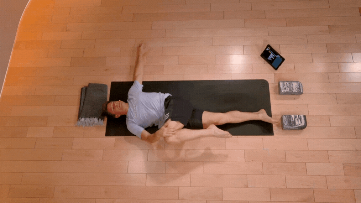 Peloton instructor Denis Morton demonstrates Supine Twist as a lower back yoga pose.