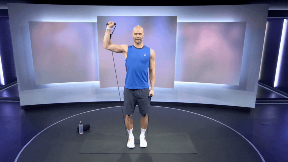 Peloton instructor Marcel Maurer demonstrates a single-arm resistance band shoulder press.