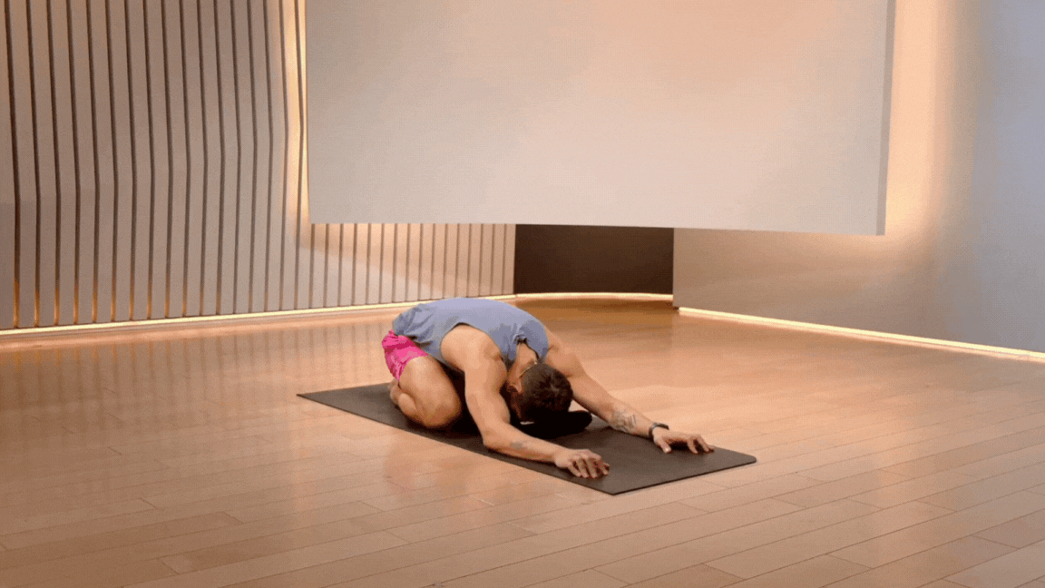 Peloton instructor Matty Maggiacomo does child's pose during a cooldown stretch class.