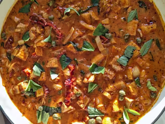 A bowl of One-Pot Marry Me Tofu with onion, garlic, tomatoes, herbs, basil and capers.