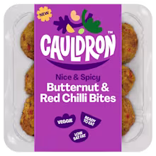 Cauldron Butternut & Red Chilli Bites in white packaging with a purple sleeve featuring the Cauldron logo and packaging weight. Six butternut squash bites can be seen behind the packaging sleeve.