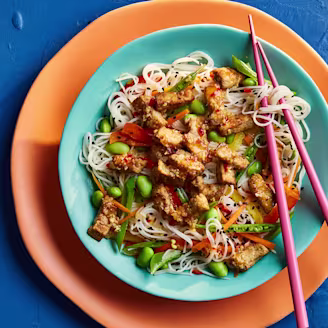 Marinated Tofu with Asian Noodles Salf on a blue plate with pink chopsticks 