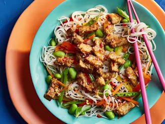 Marinated Tofu with Asian Noodles Salf on a blue plate with pink chopsticks