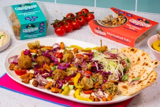 A sharing board of hummus, Cauldron Falafel and Tofu on a table with Cauldron packs.