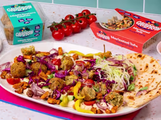 A sharing board of hummus, Cauldron Falafel and Tofu on a table with Cauldron packs.
