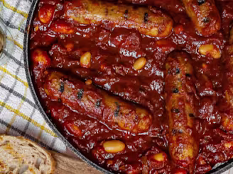 Boston Beans and Cauldron Sausage casserole served in a dark dish with bread on the side