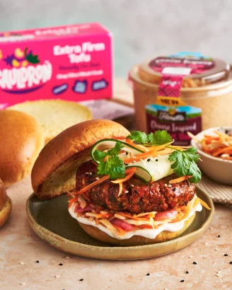 Sweet and sticky tofu burger looking delicious on a beige worktop.