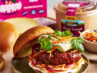Sweet and sticky tofu burger looking delicious on a beige worktop.