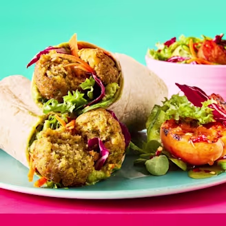 A stack of hot honey falafel and salad wraps on a light blue plate with a grilled apricot side salad.