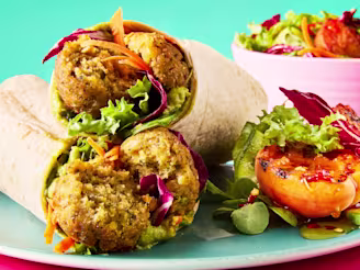 A stack of hot honey falafel and salad wraps on a light blue plate with a grilled apricot side salad.