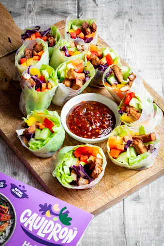 Tofu rolls wrapped in rice paper with colourful vegetables and dipping sauce.