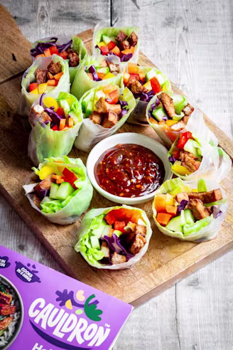 Tofu rolls wrapped in rice paper with colourful vegetables and dipping sauce.