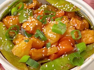 A Sweet & Sour Stir-Fry with Cauldron tofu pieces, pineapple, peppers, snap peas and rice in a soy sauce.