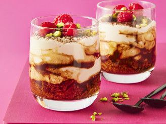 Two tiramisu in glass cups with a pink background 