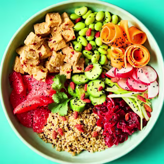 Summer Tofu Poke Bowl of Cauldron Tofu Pieces with salad on a teal background.