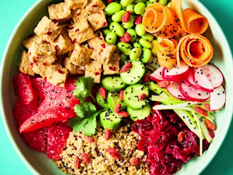 Summer Tofu Poke Bowl of Cauldron Tofu Pieces with salad on a teal background.