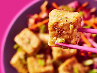 Cauldron Extra Firm Tofu being picked up with chopsticks with a bowl in the background