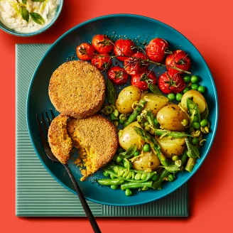 Pumpkin & Caramelised Onion Veggie Bakes with a tomato salad on the side on a plate