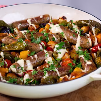 Spanish-inspired sausage traybake with Cauldron sausages topped served in a large white dish