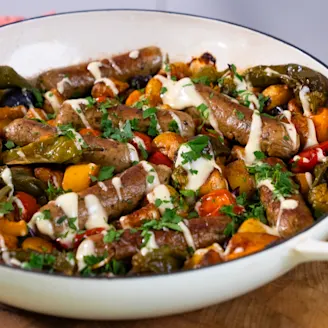 Spanish-inspired sausage traybake with Cauldron sausages topped served in a large white dish