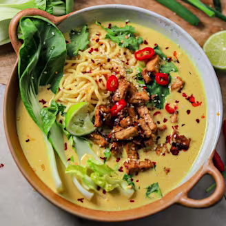 Curried tofu ramen in a bowl using Cauldron Tofu alongside veggies 