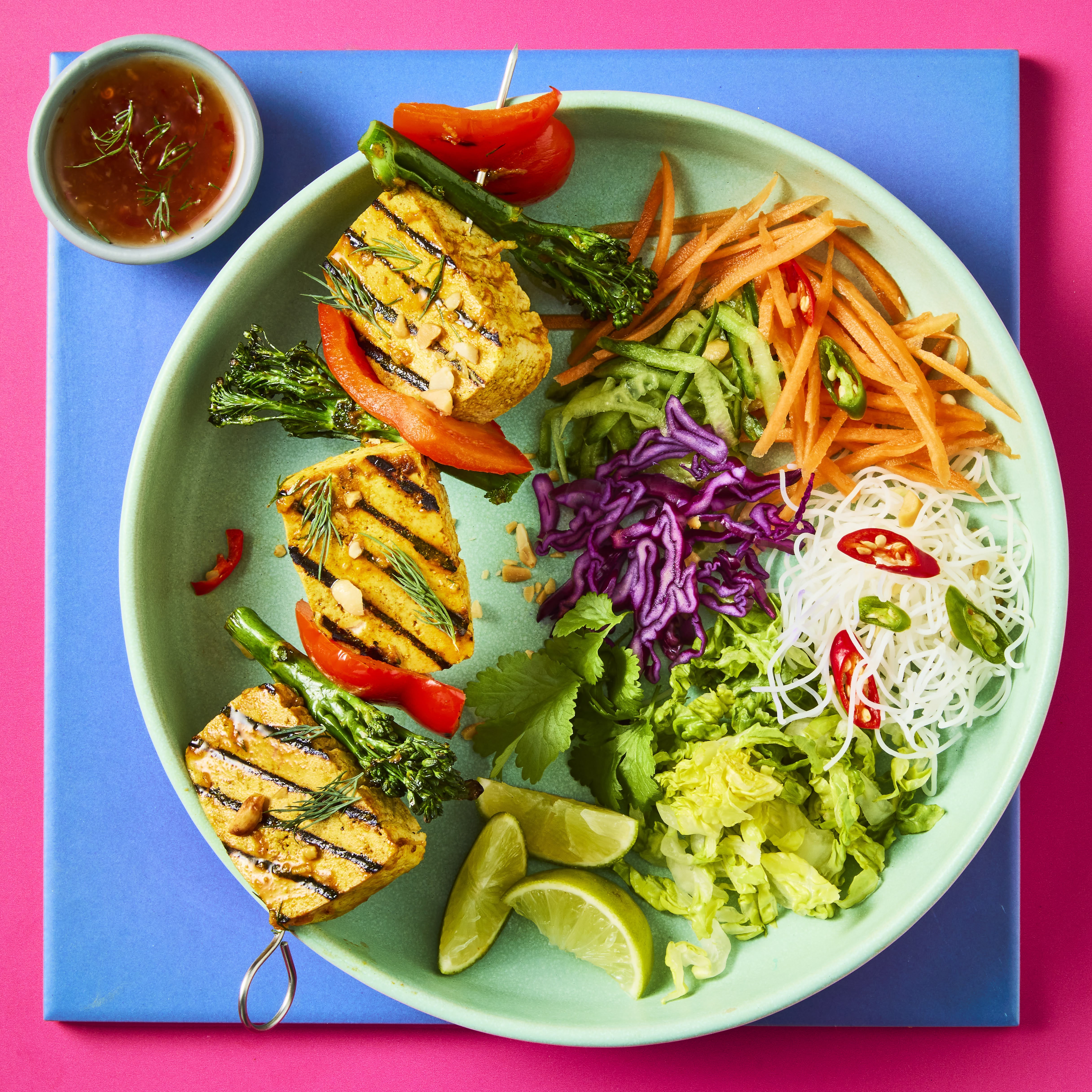 Vietnamese Tofu Skewers with Cauldron Extra Firm Tofu and salad in a green bowl on a blue background.
