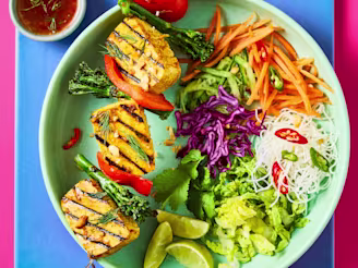 Vietnamese Tofu Skewers with Cauldron Extra Firm Tofu and salad in a green bowl on a blue background.