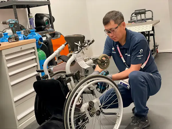 Paris 2024 Rollstuhltechniker bei der Reparatur eines Rollstuhls im Reparatur-Service-Center im Paralympischen Dorf in Paris.