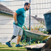 MyFit TT user Beytullah Demir works in his garden and pushes a wheelbarrow around.