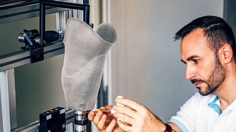 Wolid Sharif, O&P professional, screws the MyFit TT prosthetic socket to a foot in his workshop.