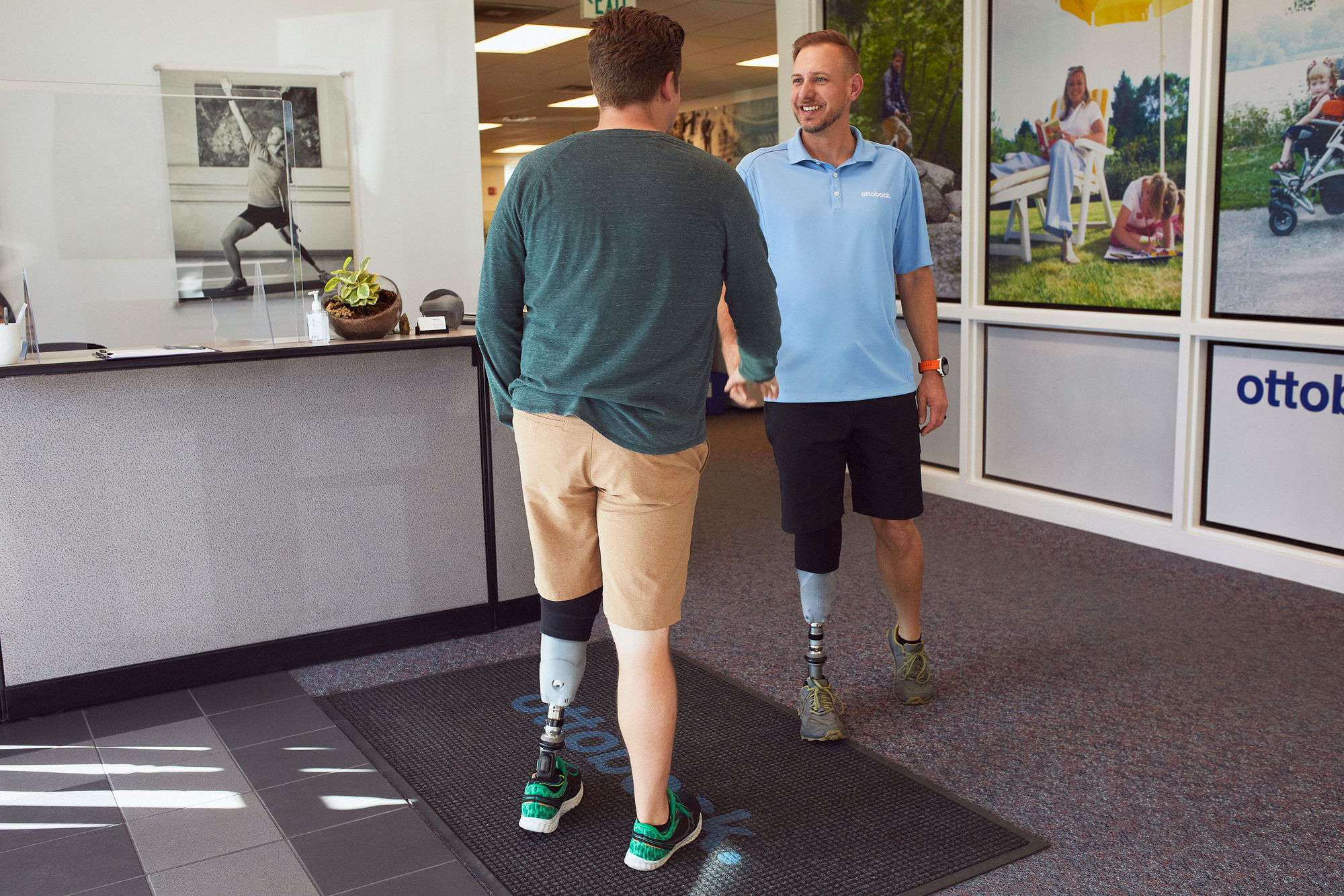 Jeffrey Waldmuller, Prothetiker, begrüßt einen Beinprothesen-Träger. Beide tragen den MyFit TT Schaft.