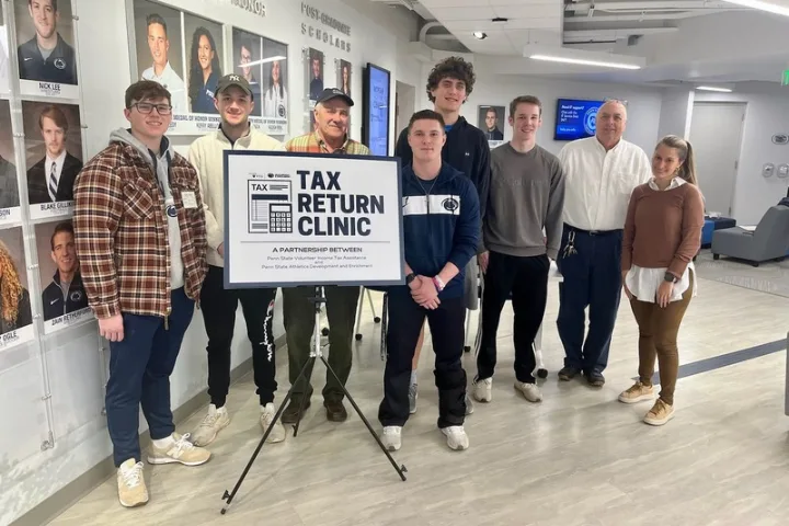 Volunteer Income Tax Assistance (VITA) team stands by a tax return clinic sign