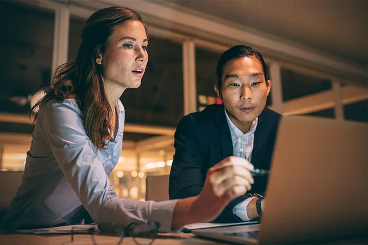 Two co-workers reviewing data on computer
