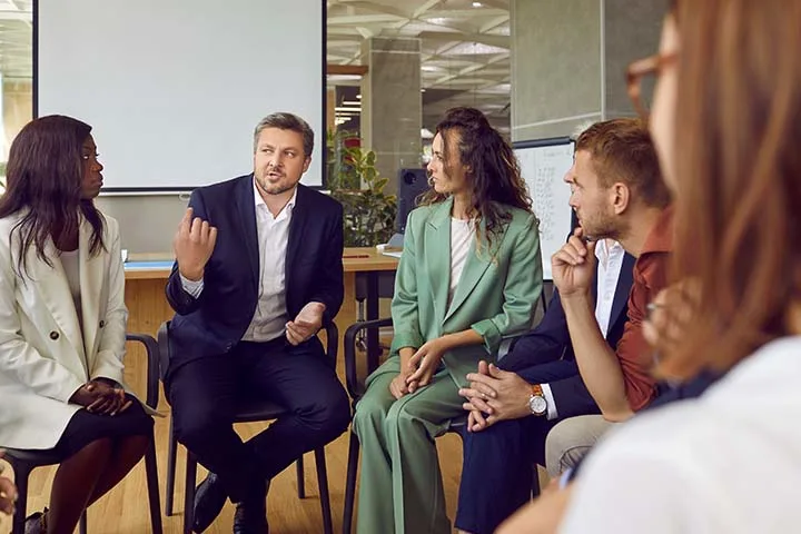 Man speaking in front of co-workers