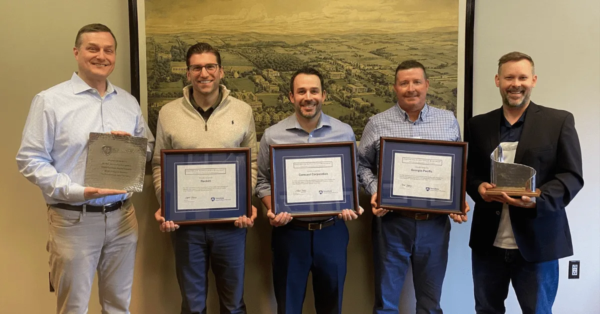Group photo of corporate sponsors and milestone certificates