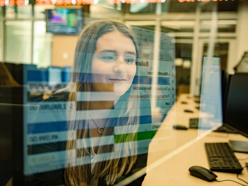 Computer screen with graphs is overlaid on student