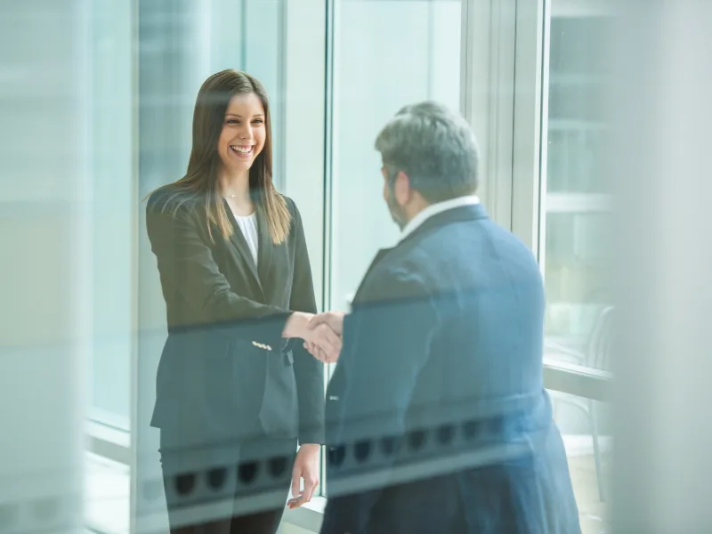 Two people in professional attire shake hands