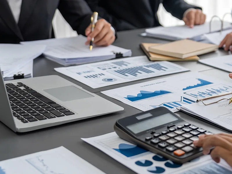 Auditor and accountant team working in office, analyzing financial data and accounting record with calculator.