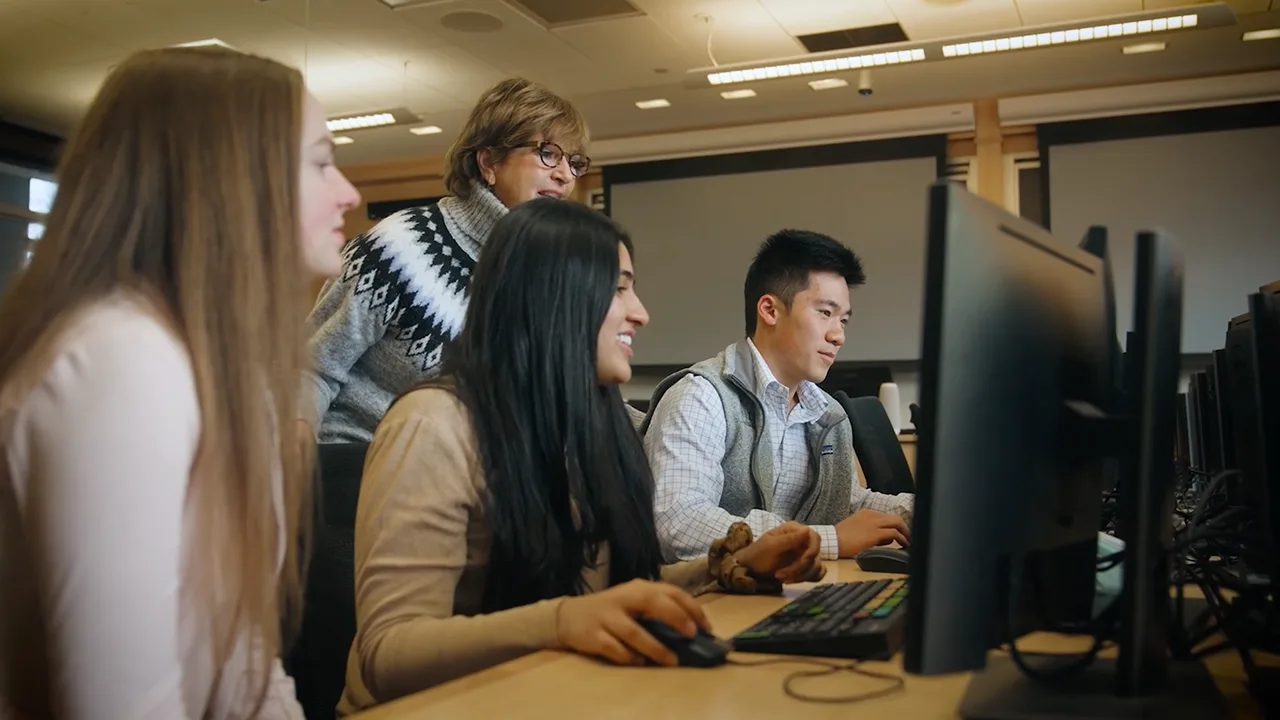 Professor helping students on computers