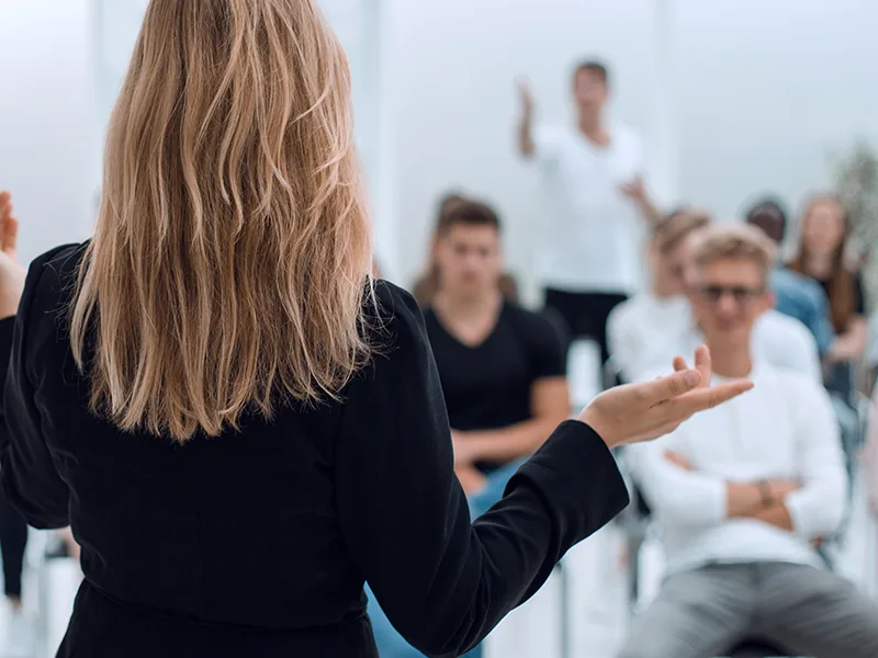 Background image of a business seminar in a bright conference room