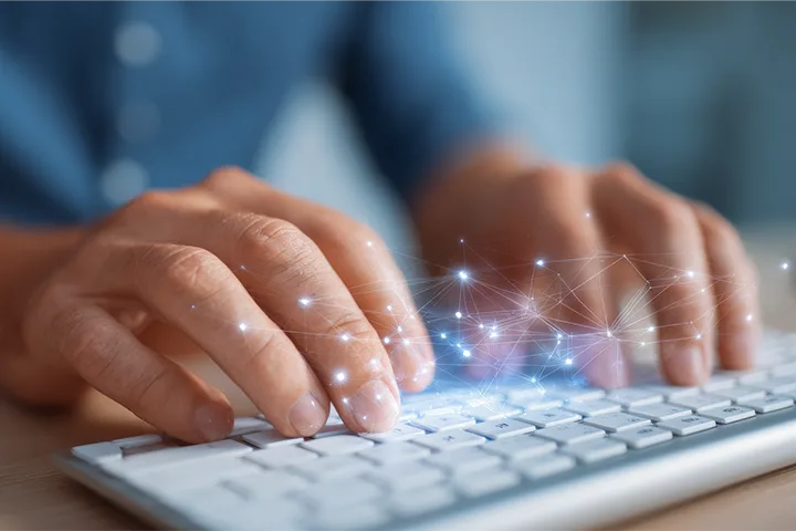 Hands typing on keyboard with computer graphics overlayed on top