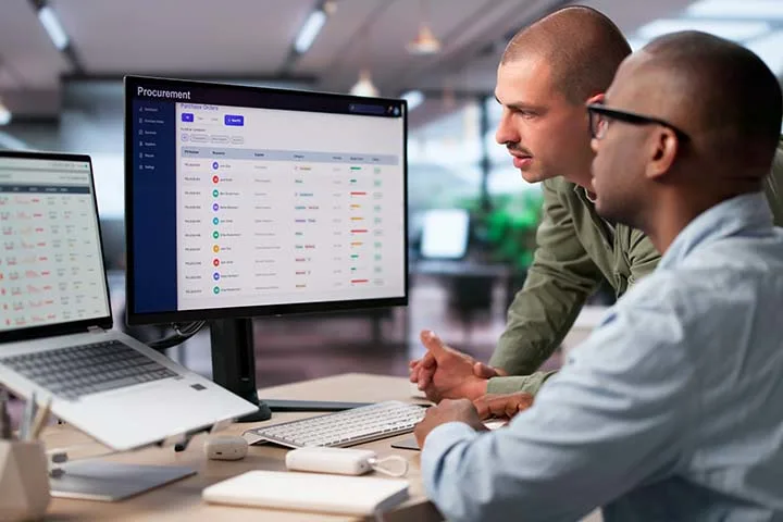 Co-workers looking at a procurement dashboard