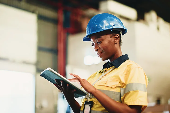 Woman in warehouse working on iPad.