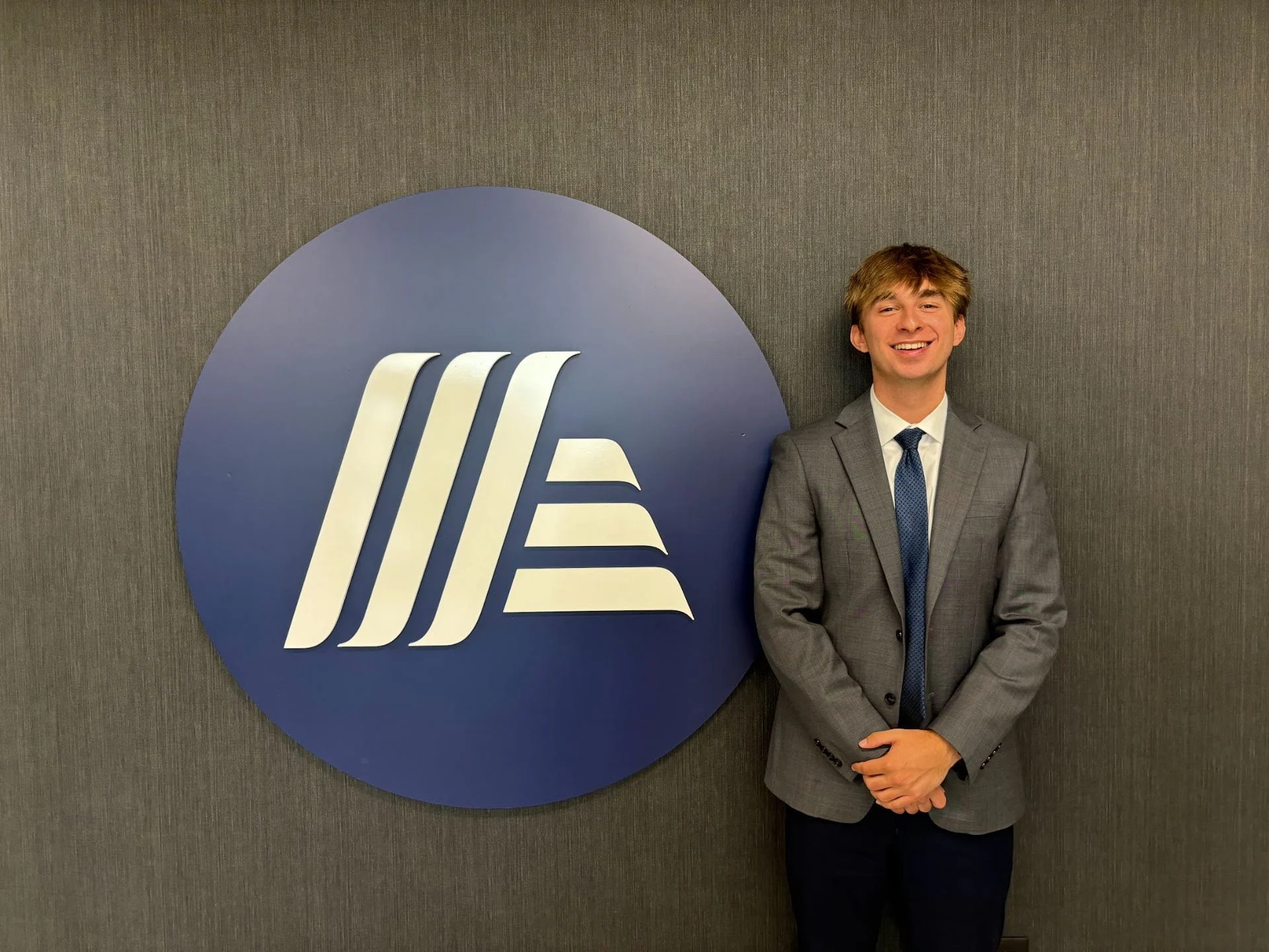 Portrait of Hunter Badamo standing beside the Aldi logo.