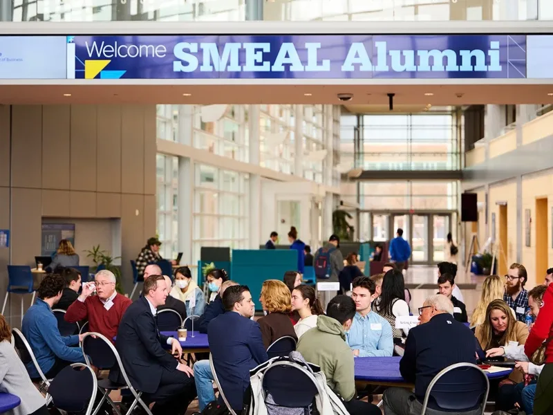 Crowd of alumni and students in front of a Smeal Alumni sign