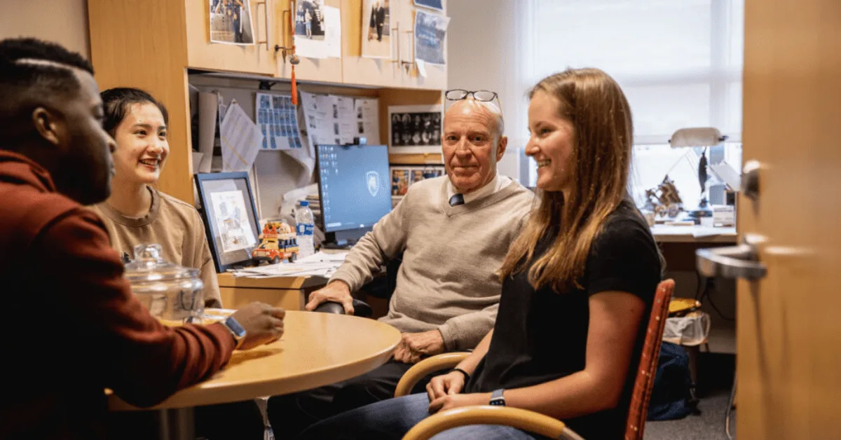 Photo of Bob Novack meeting with 3 students